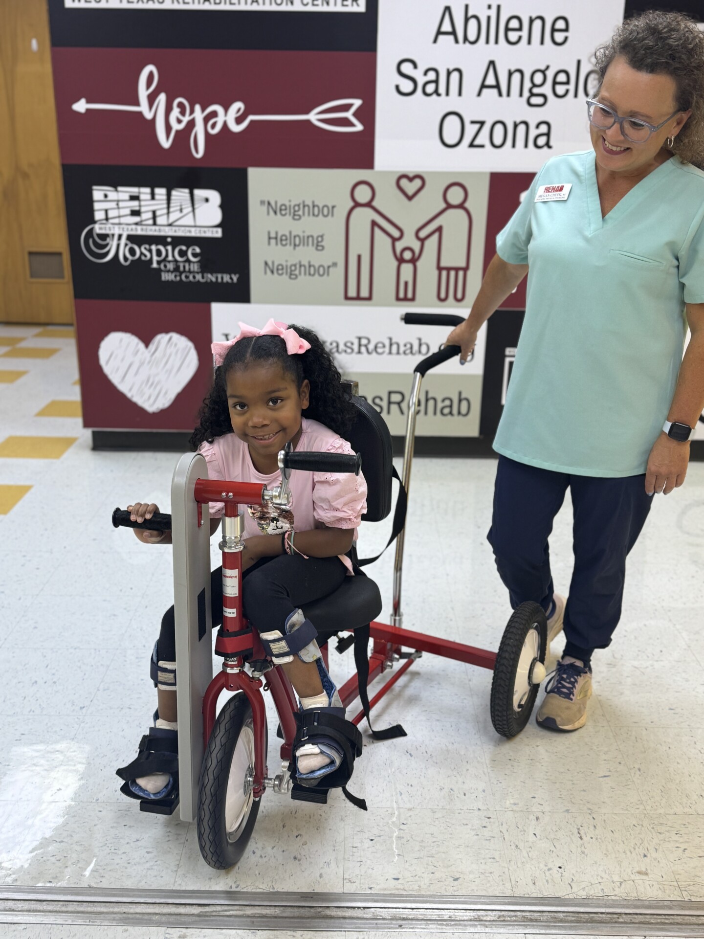 Child riding a specialized therapy bike at West Texas Rehab to improve leg movement and strength.