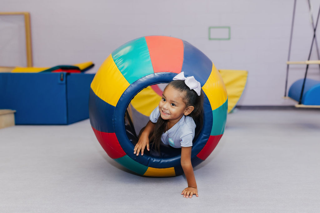 Pediatric patient playing inside a foam ball at West Texas Rehab to enhance motor skills and sensory development.