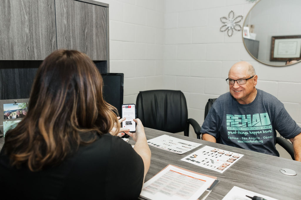 Patient receiving hearing aid evaluation and care at West Texas Rehab's audiology department.