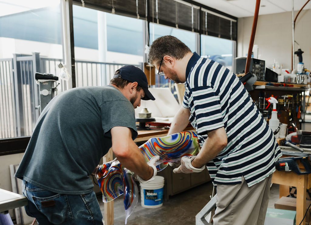 Two employees at West Texas Rehab working together to form a prosthetic leg for a patient.