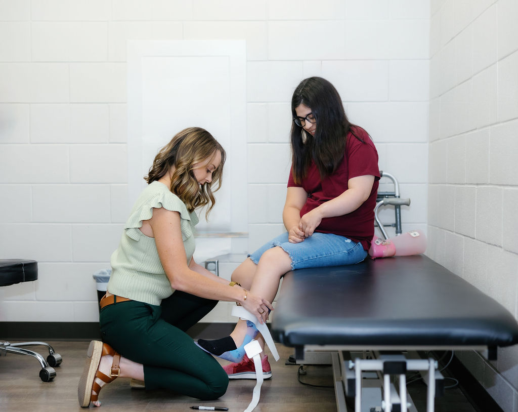 Patient and therapist at West Texas Rehab assessing ankle mobility and strength during a fitting session.