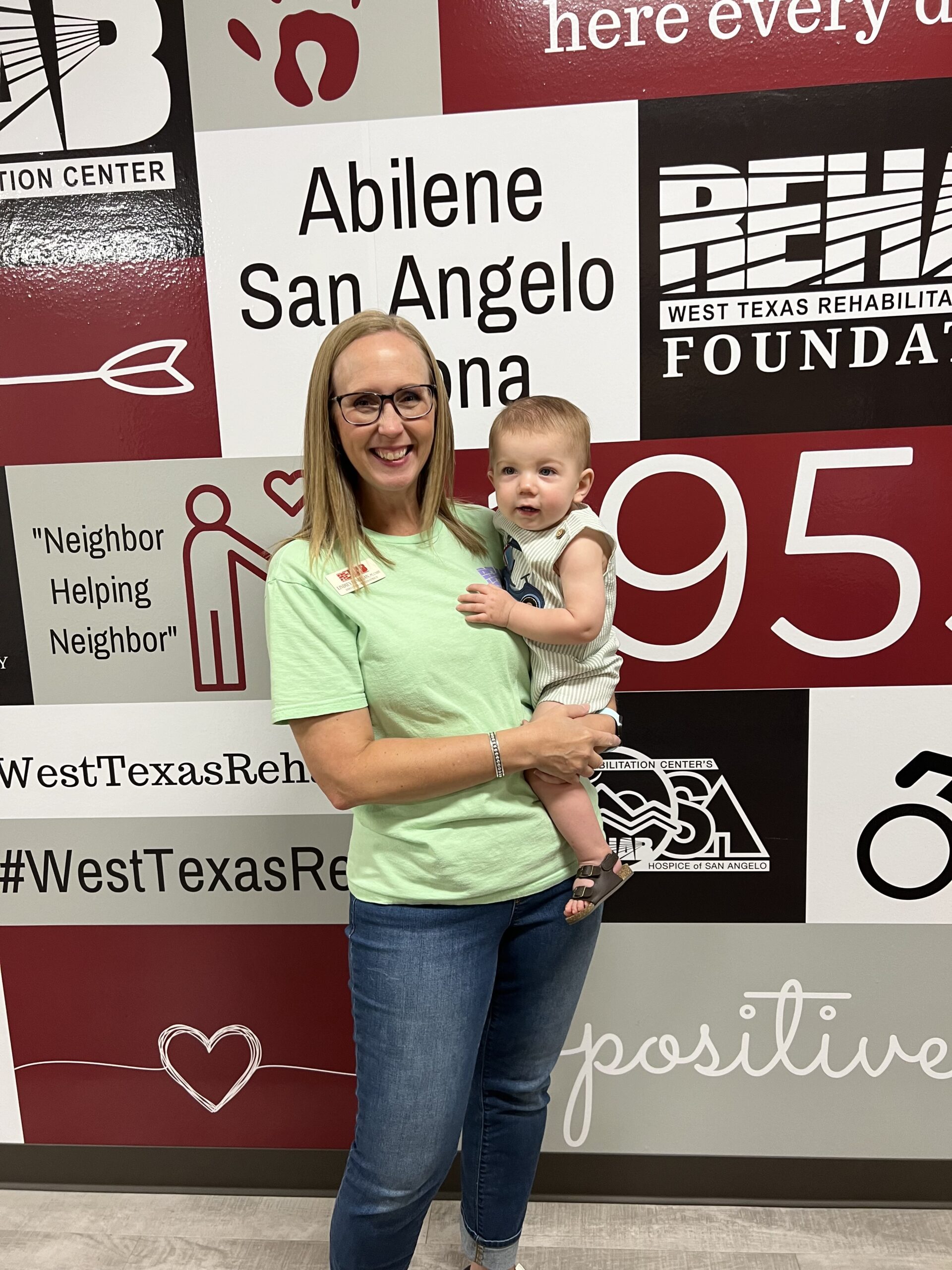 Lindsey McMillan holding a patient at West Texas Rehab, providing compassionate care during therapy.